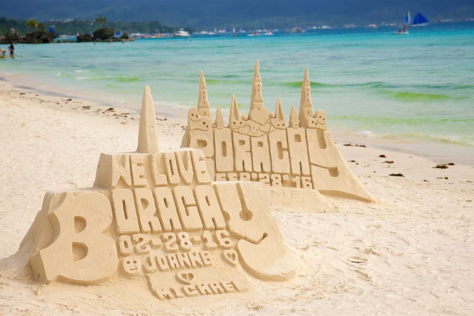 Un castillo de arena en la playa con un mensaje grabado.