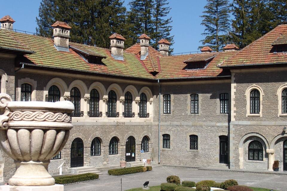 A historic building with a courtyard, stone walls, and a tiled roof.