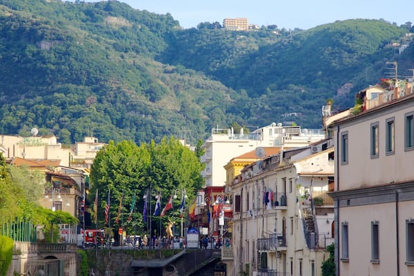 Une ville située sur une colline, avec des bâtiments, des arbres et une structure imposante qui se dresse au sommet.
