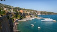 A coastal town with a marina, boats, and historic buildings.