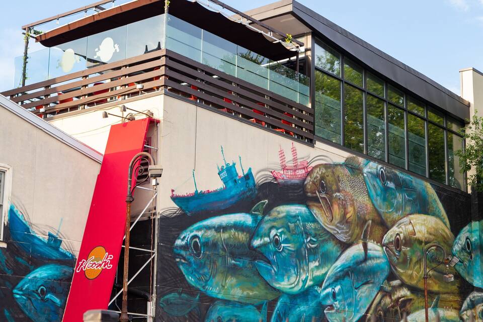 A building with a mural of fish and a red banner.