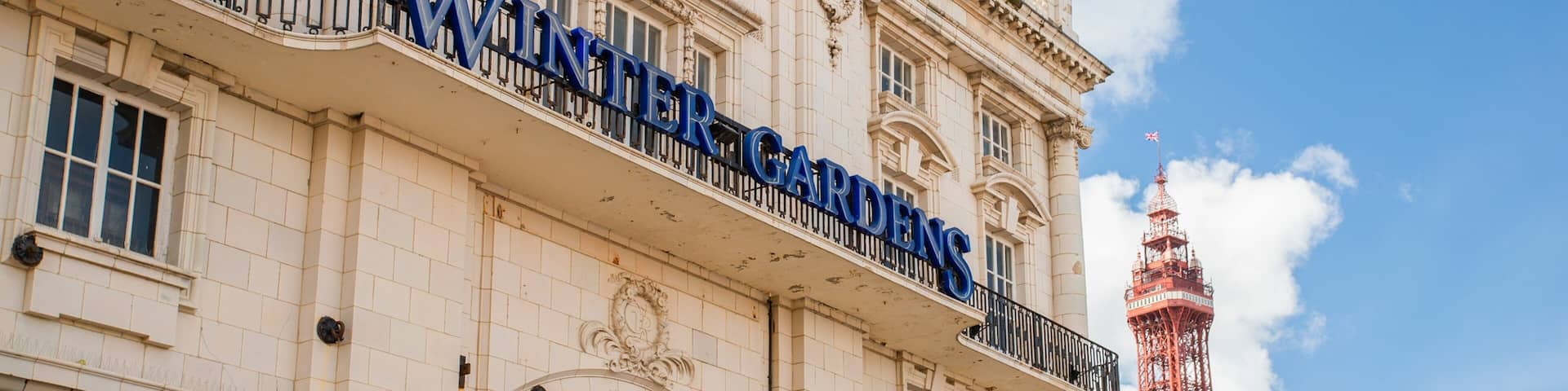 El exterior del Teatro Jardín de Invierno, con detalles arquitectónicos ornamentales y una torre roja al fondo.
