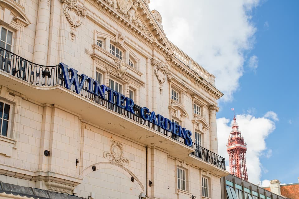 El exterior del Teatro Jardín de Invierno, con detalles arquitectónicos ornamentales y una torre roja al fondo.