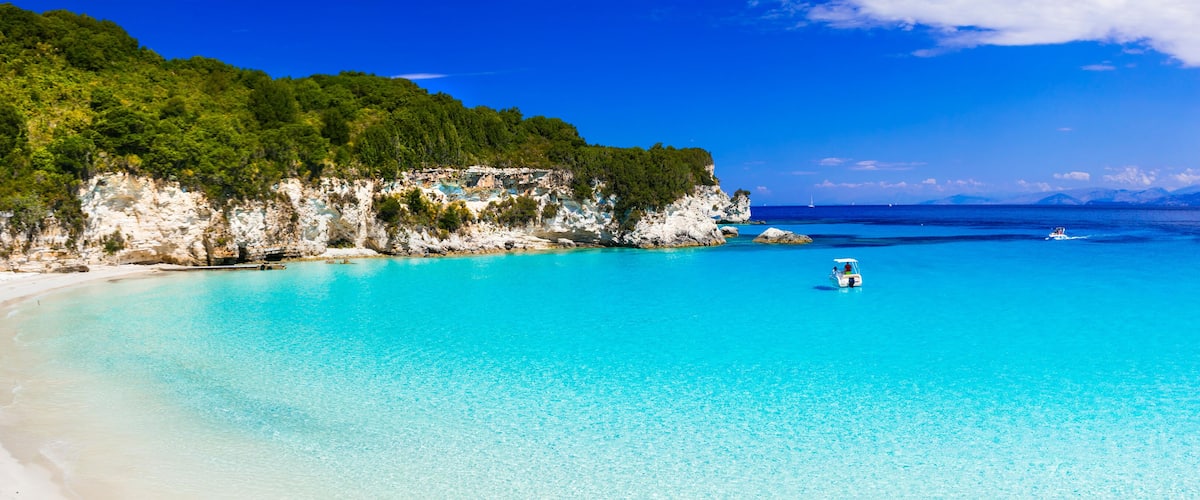 A turquoise beach with white cliffs and a clear blue sea.