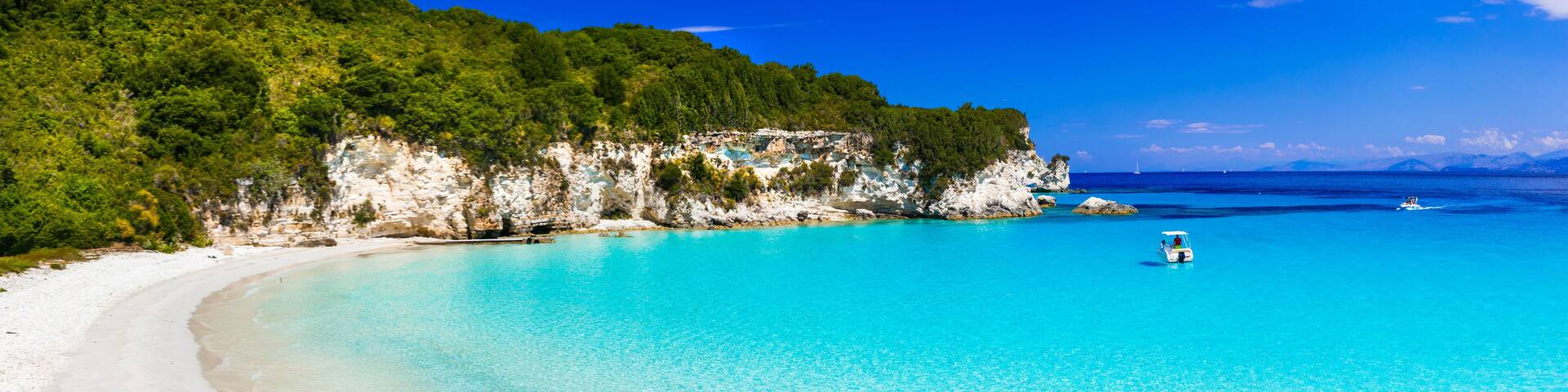 A turquoise beach with white cliffs and a clear blue sea.