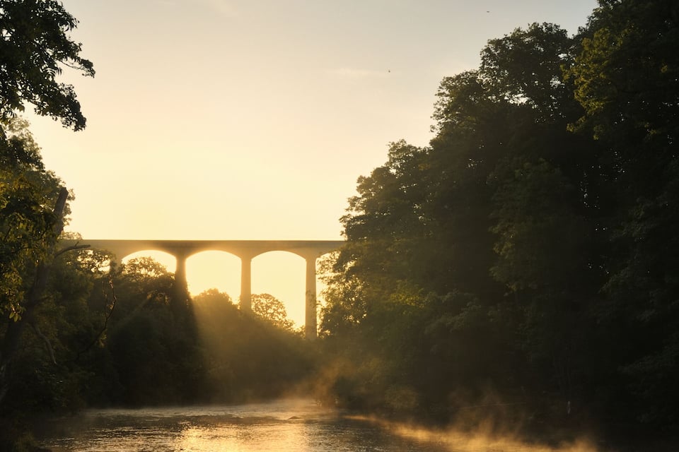 A river with a bridge in the background.