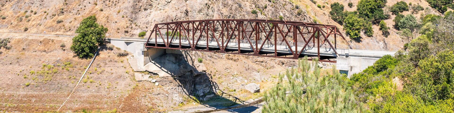 Bridge going over Coyote Creek in South San Francisco Bay Area, California; low water level visible due to existent drought conditions, but also due to the planned draining of Anderson Reservoir;