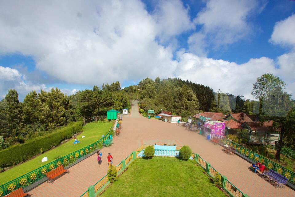 A park with a paved walkway, green lawns, and trees.