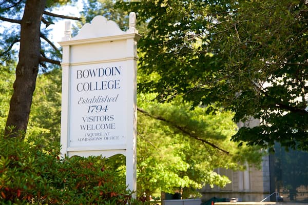 Placa indicativa do Bowdoin College, com uma árvore e vegetação ao fundo.