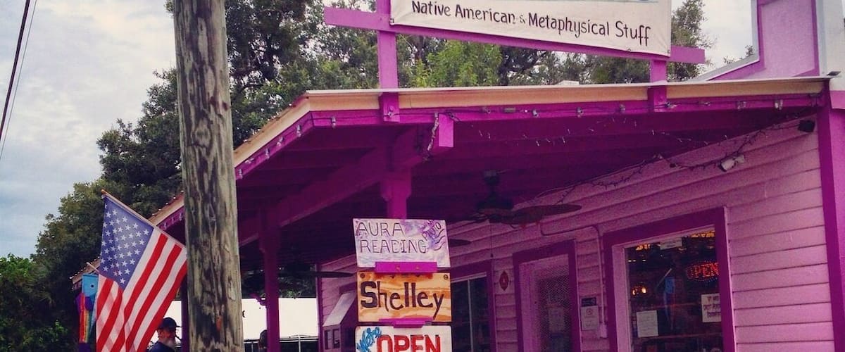 A storefront with a sign reading "Purple Rose Readings" and "Native American & Metaphysical Stuff".