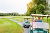 People, golf cart and outside course in nature, happy and relax in transport path or country club hobby on weekend break. Fitness, driving and smile for sport game conversation, golfers and together