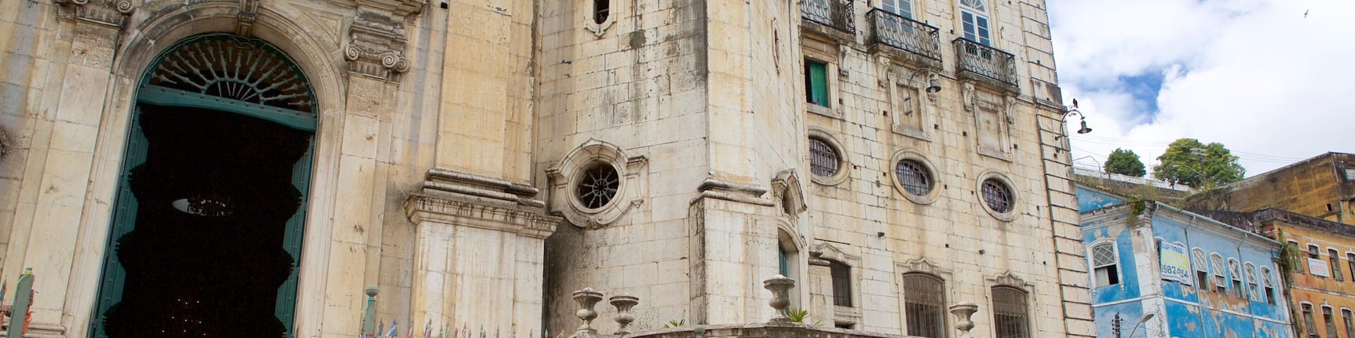 A historic building with ornate architecture, including a large arched entrance and a staircase leading to the upper floors.