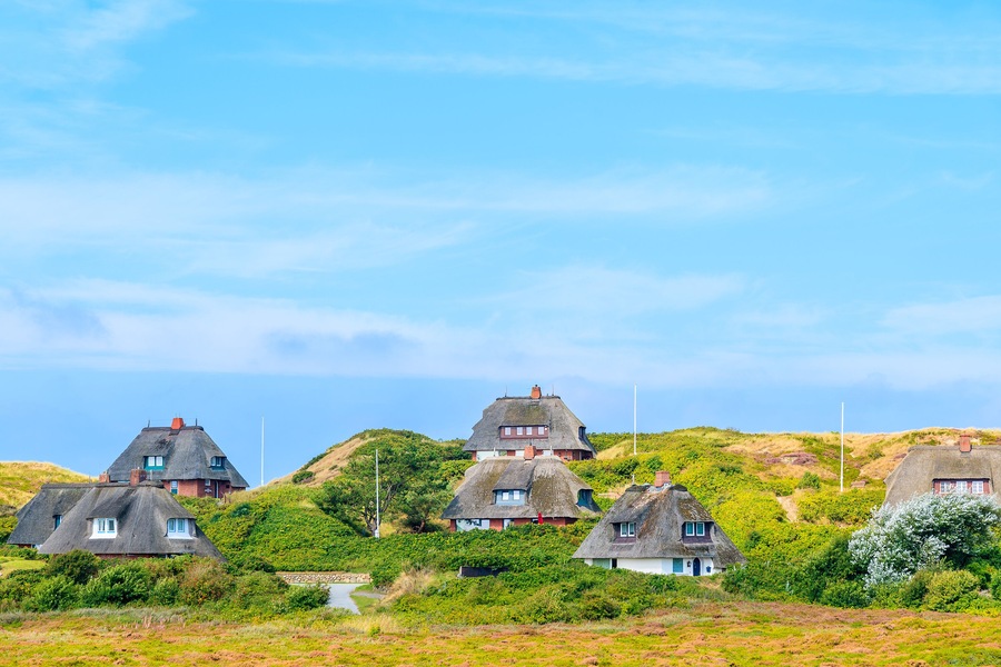 Typical Frisian houses with straw roofs on sand dunes in Kampen village, Sylt island, Germany