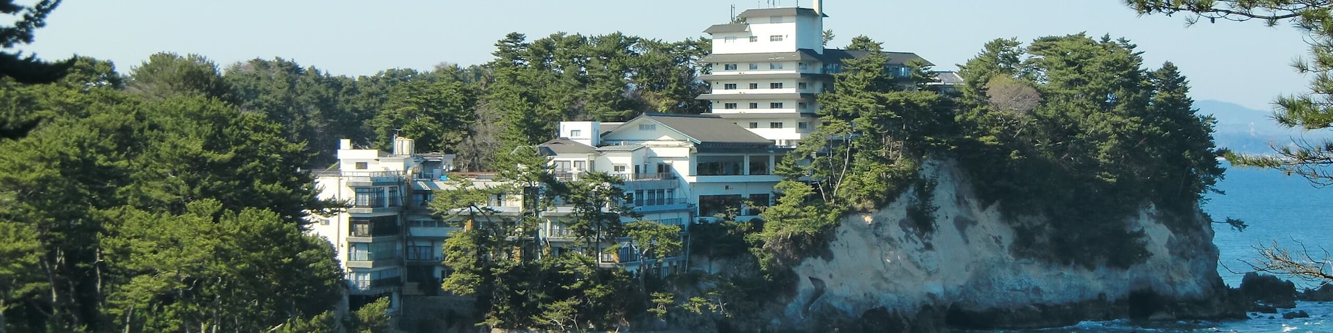 Un pueblo costero con edificios sobre un acantilado con vistas al mar.