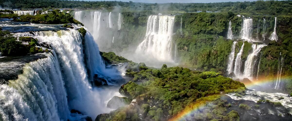 A large waterfall with multiple cascades surrounded by lush greenery.