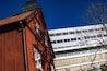 Stockholm, Sweden Oct 22, 2021 A red house contrast with the modern facade of the Karolinska Hospital.
