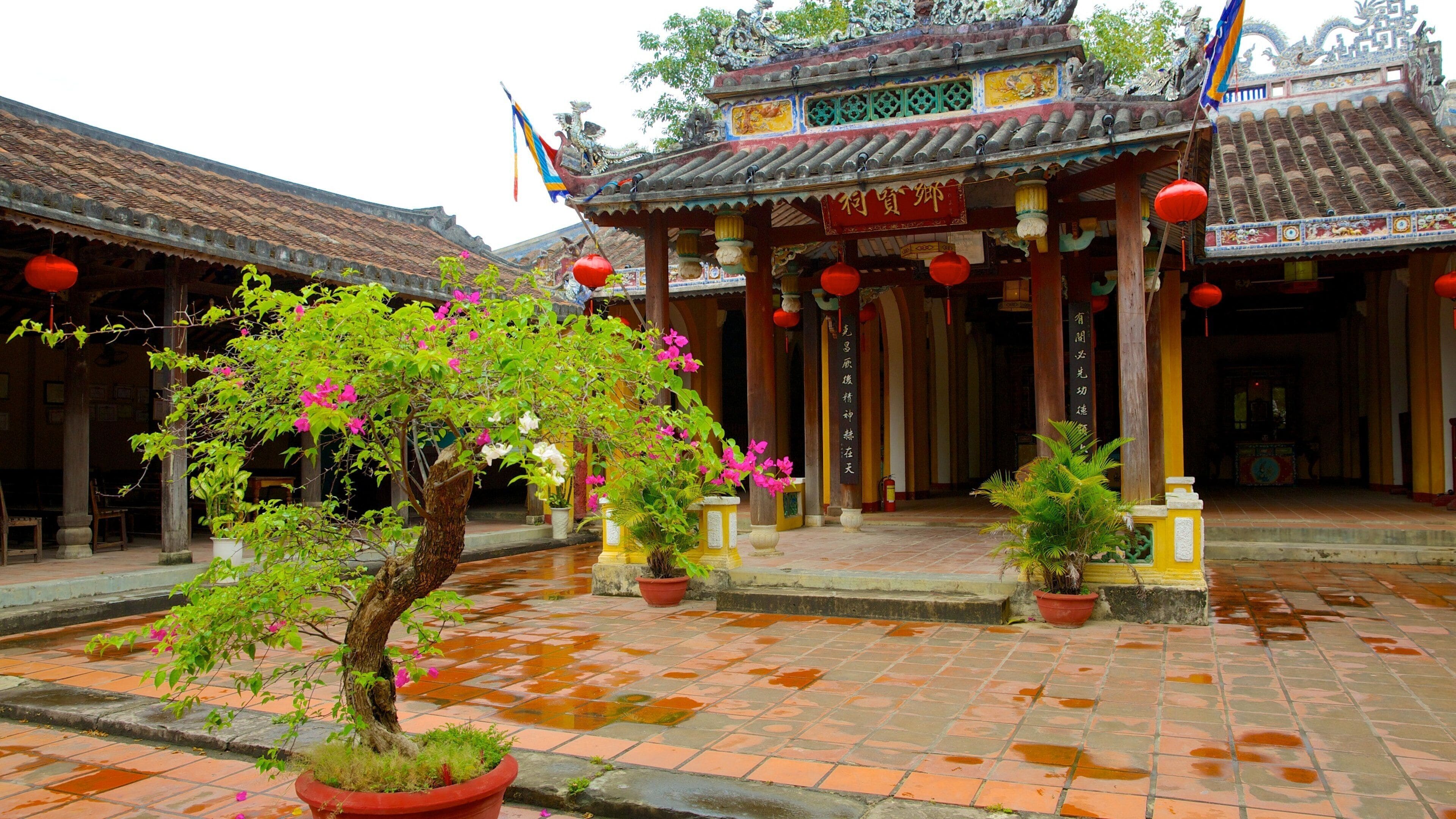 Um edifício tradicional chinês com arquitetura elaborada, incluindo um telhado telhado e lanternas vermelhas.