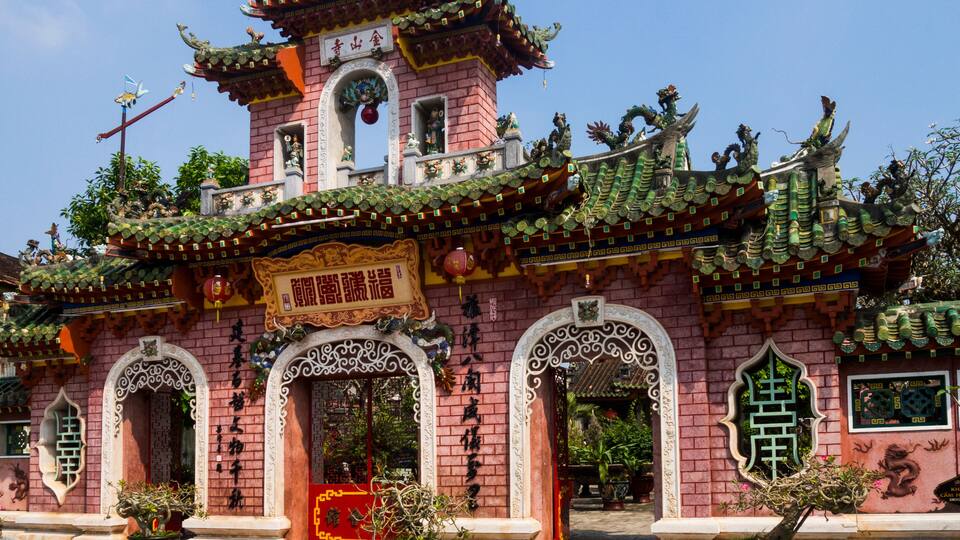 Um templo chinês tradicional com arquitetura ornamentada, incluindo um telhado em vários níveis e esculturas detalhadas.