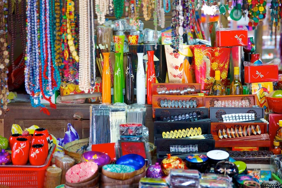 Un puesto de mercado vibrante, con cuentas coloridas, jarrones y diversos productos envasados.