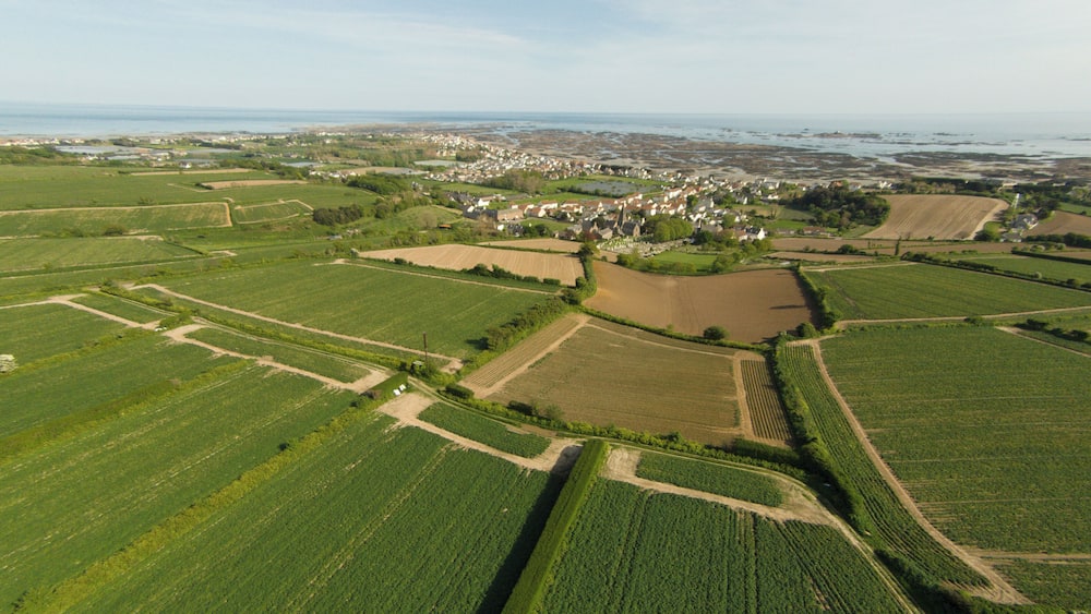 Vue aérienne d’un paysage rural avec des champs, un village et une côte.