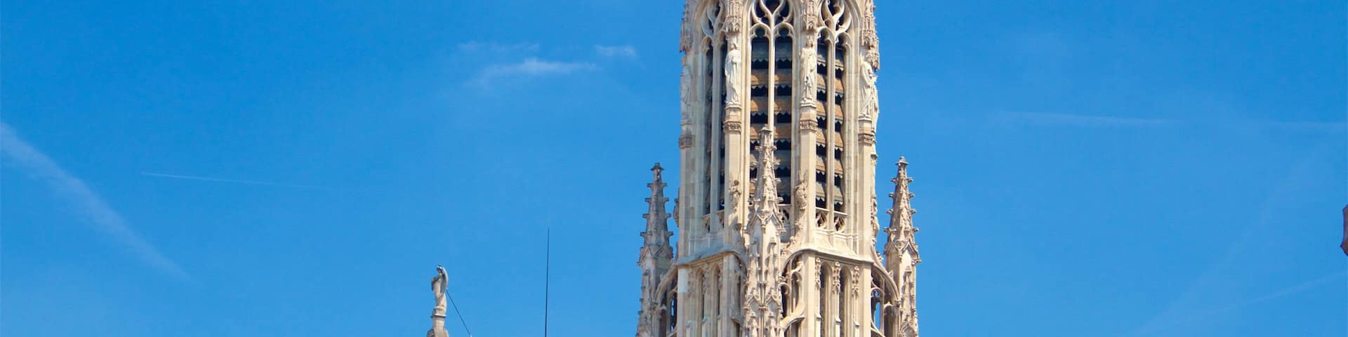 A tall, ornate tower with intricate architectural details and a clock face.