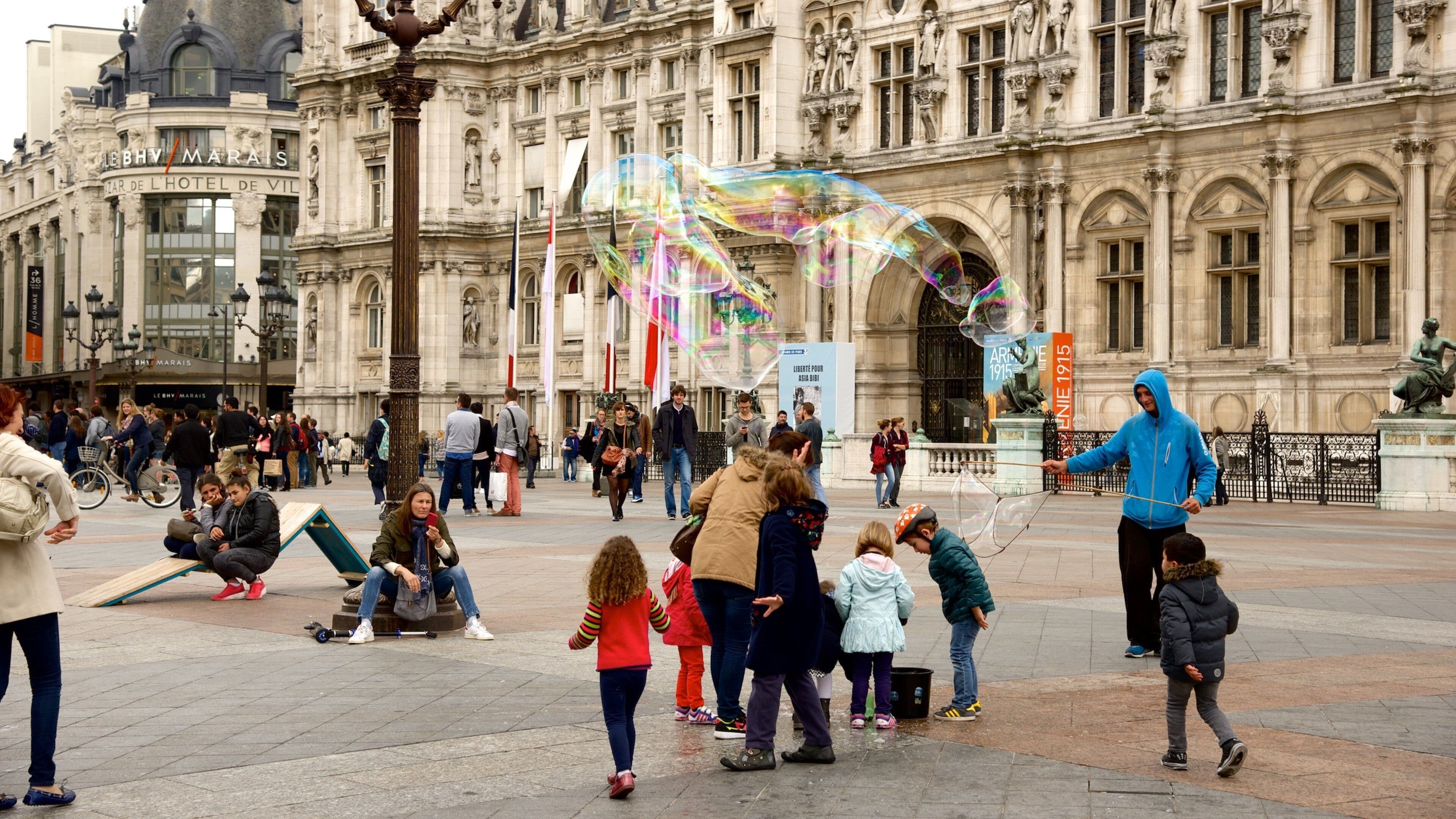 Uma praça pública movimentada, com edifícios históricos e pessoas caminhando.