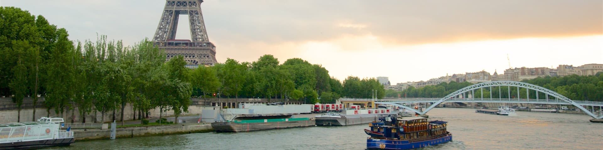 The Eiffel Tower, a river with boats, and a bridge.