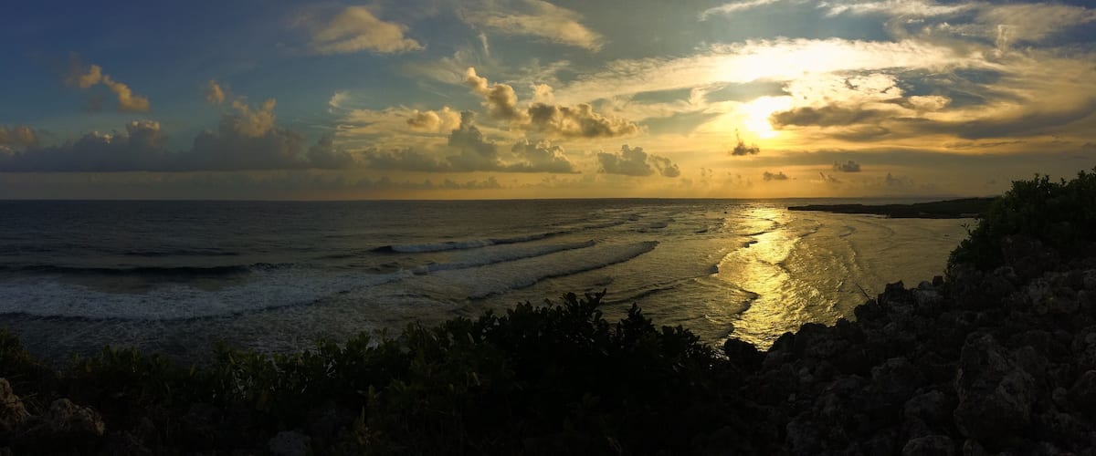 A sunset over the ocean with waves reflecting the sky.