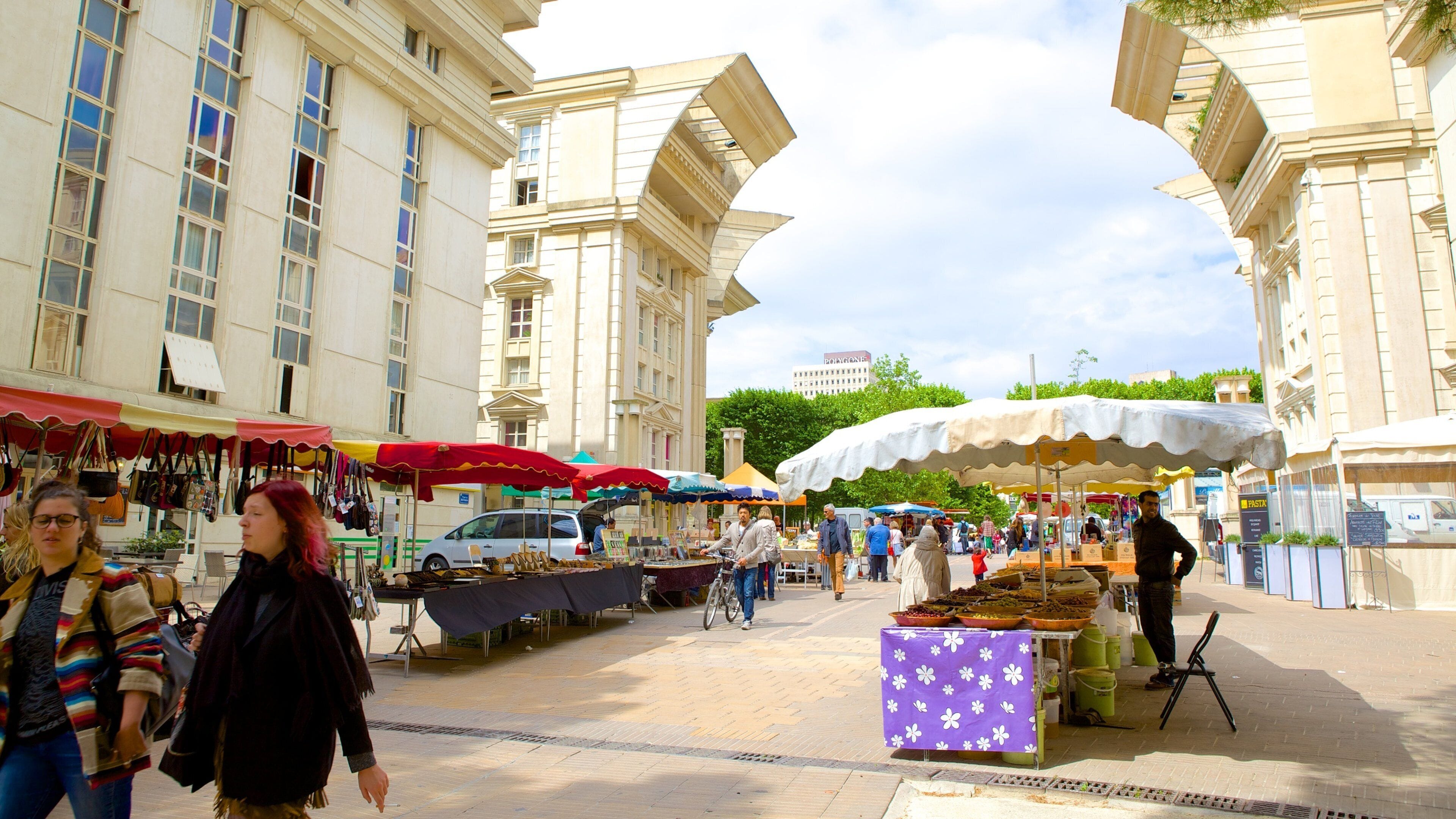 A bustling outdoor market with vendors and shoppers.