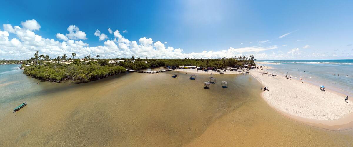 A beach with clear waters, a dock, and a pier.