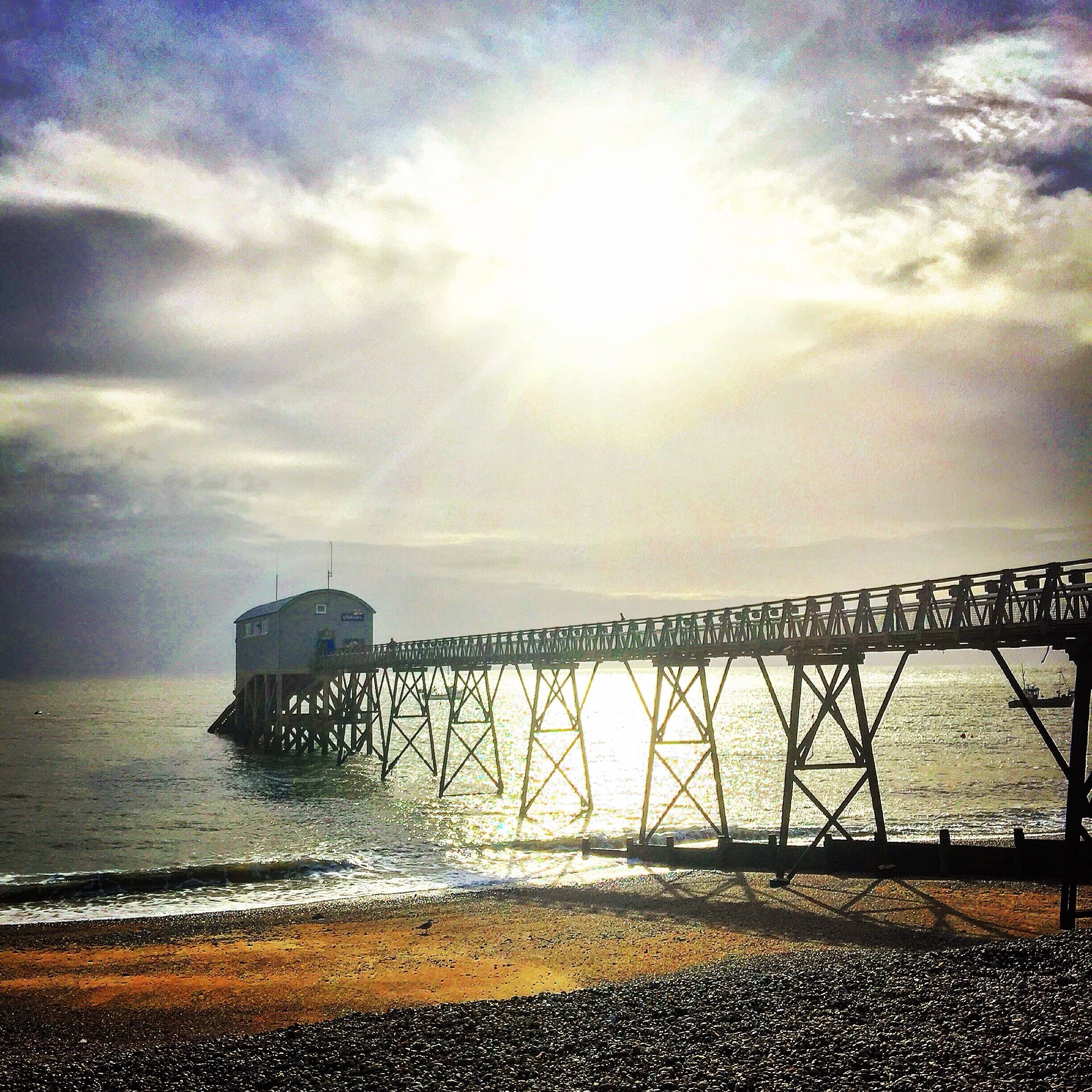 A pier extending into the water with a building at the end.