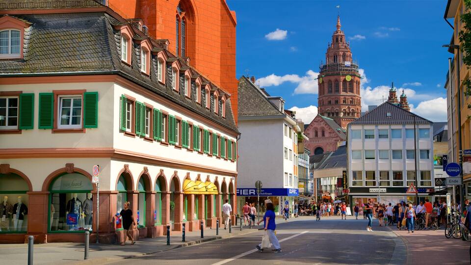 A street with historic buildings, a prominent clock tower, and a busy pedestrian area.
