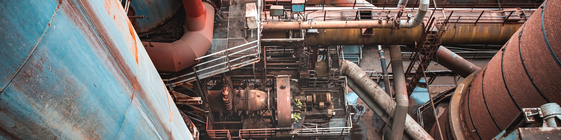 Una gran instalación industrial con tanques y tuberías oxidadas.