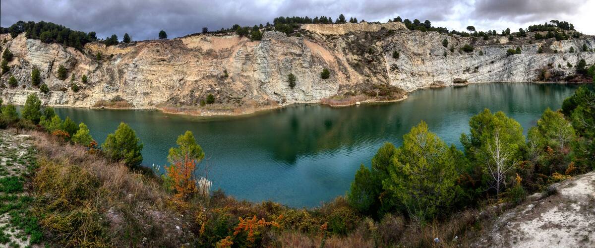 A lake surrounded by rocky cliffs and sparse vegetation.