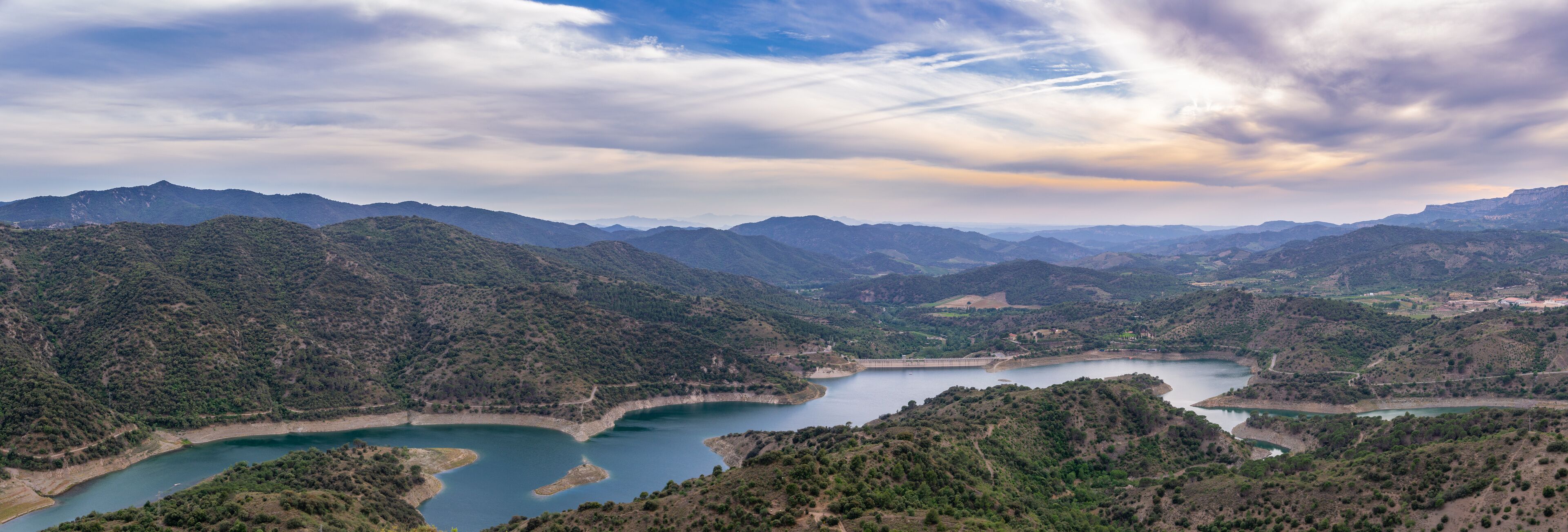 A mountainous landscape with a large reservoir and a dam.
