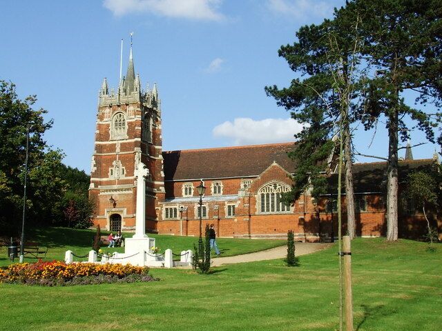 A historic church with a tall tower and a well-maintained lawn.