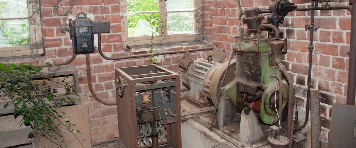An industrial room with brick walls, large windows, and various machinery.