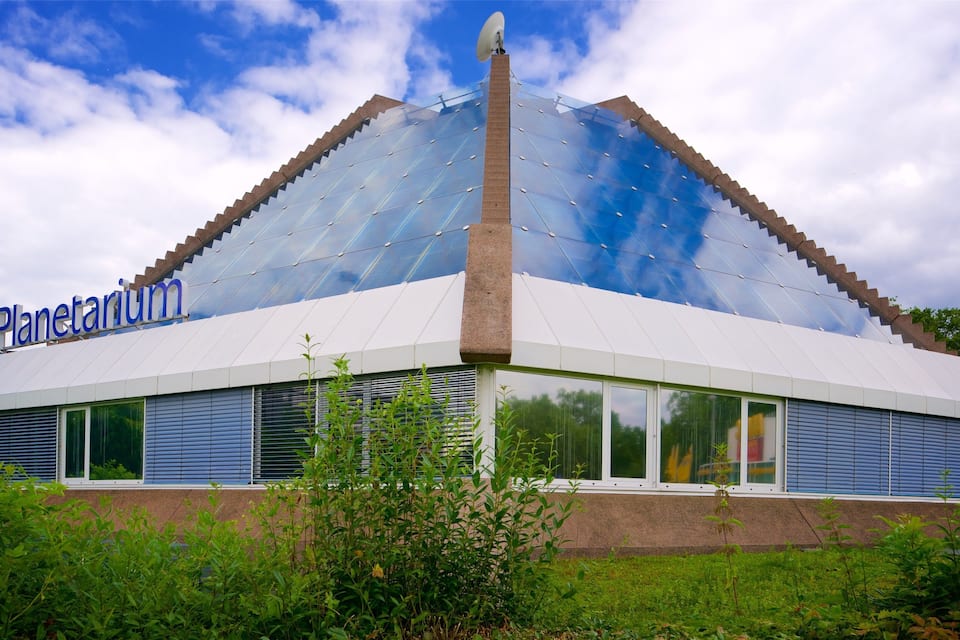 Ett planetarium med en modern design, kännetecknat av en stor glaskupol och ett framträdande centralt torn.
