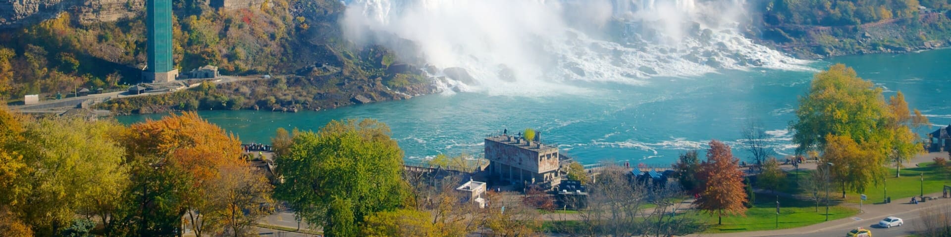 Una cascada grande con una plataforma de observación, rodeada de follaje otoñal y un río.