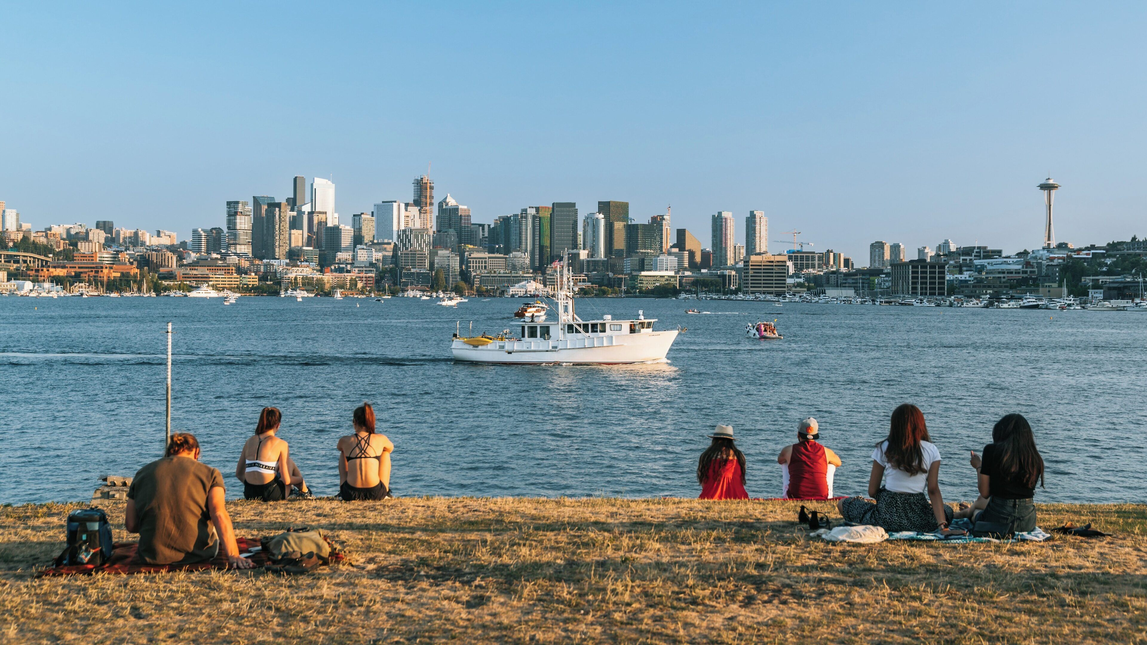 Enjoying a sunny day at Gas Works Park in Wallingford, Seattle with a view of the city skyline and a boat sailing on Lake Union