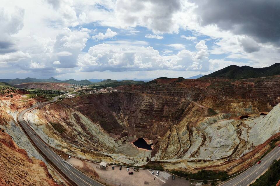 A large open-pit mine with winding roads and distant mountains.