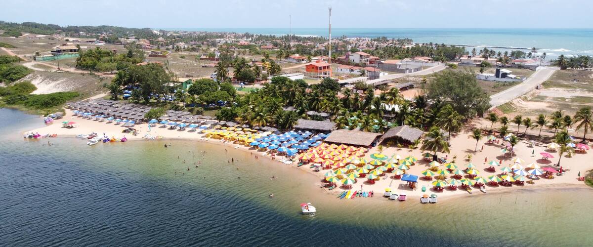 A coastal town with a beach, umbrellas, and a boat.