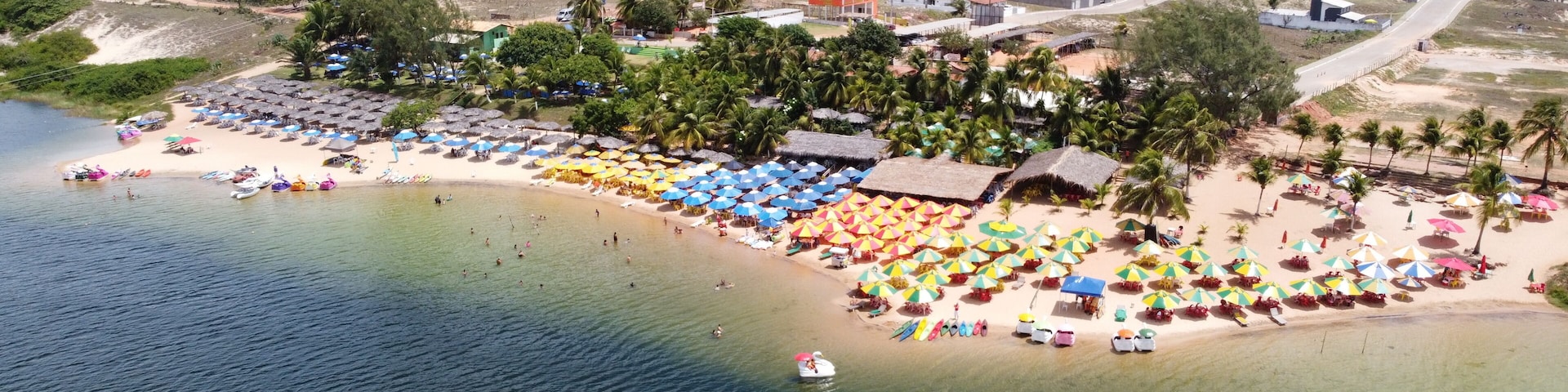 A coastal town with a beach, umbrellas, and a boat.