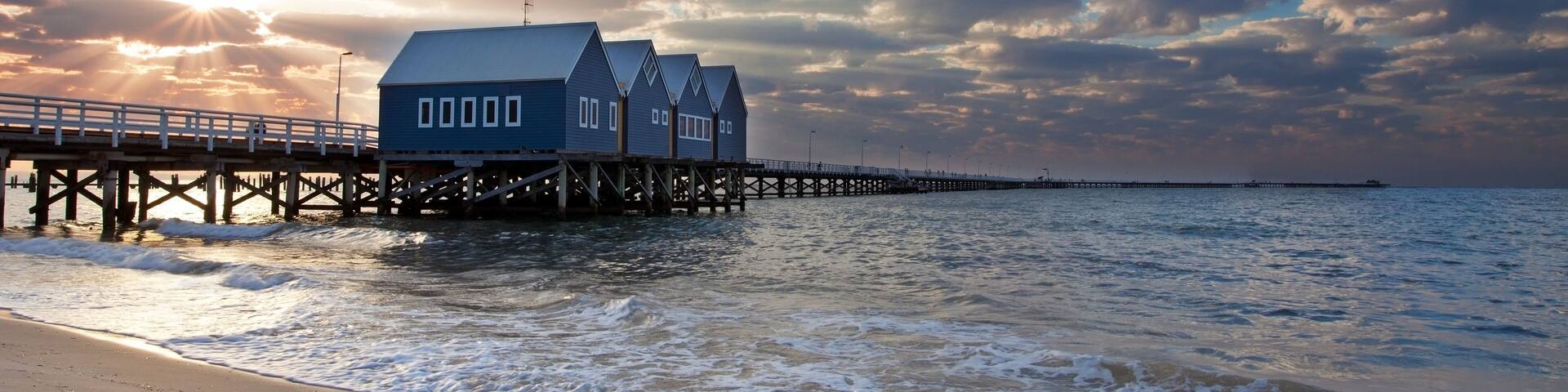 A pier extending into the sea with a building on it, under a partly cloudy sky.