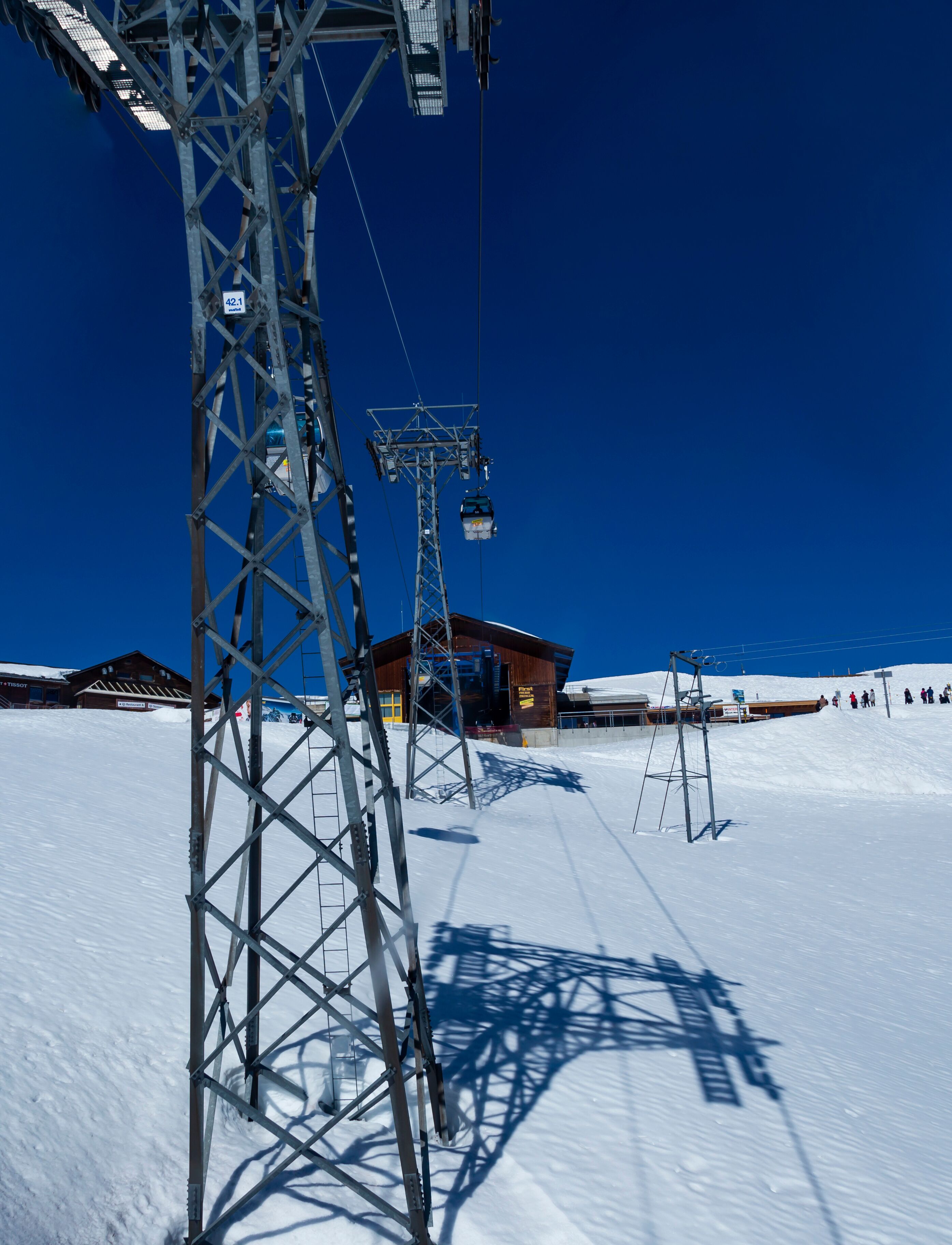 Gondola lift ( cable car ) with tower and station over snow of mountain alps, transpotation from grindelwald to First peak Switzerland Europe