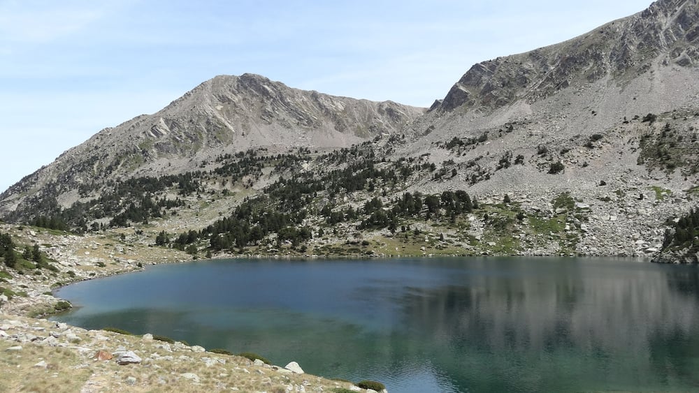 A mountain landscape with a clear lake and rocky terrain.