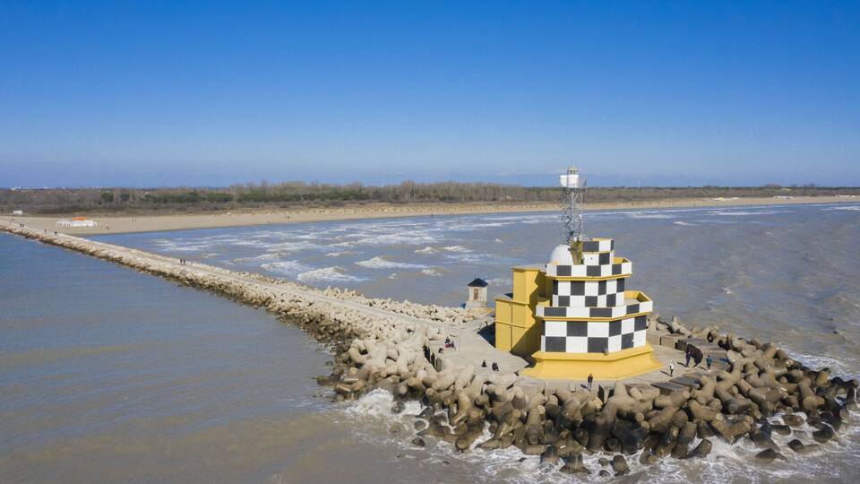 A lighthouse on a rocky outcrop in a coastal area.