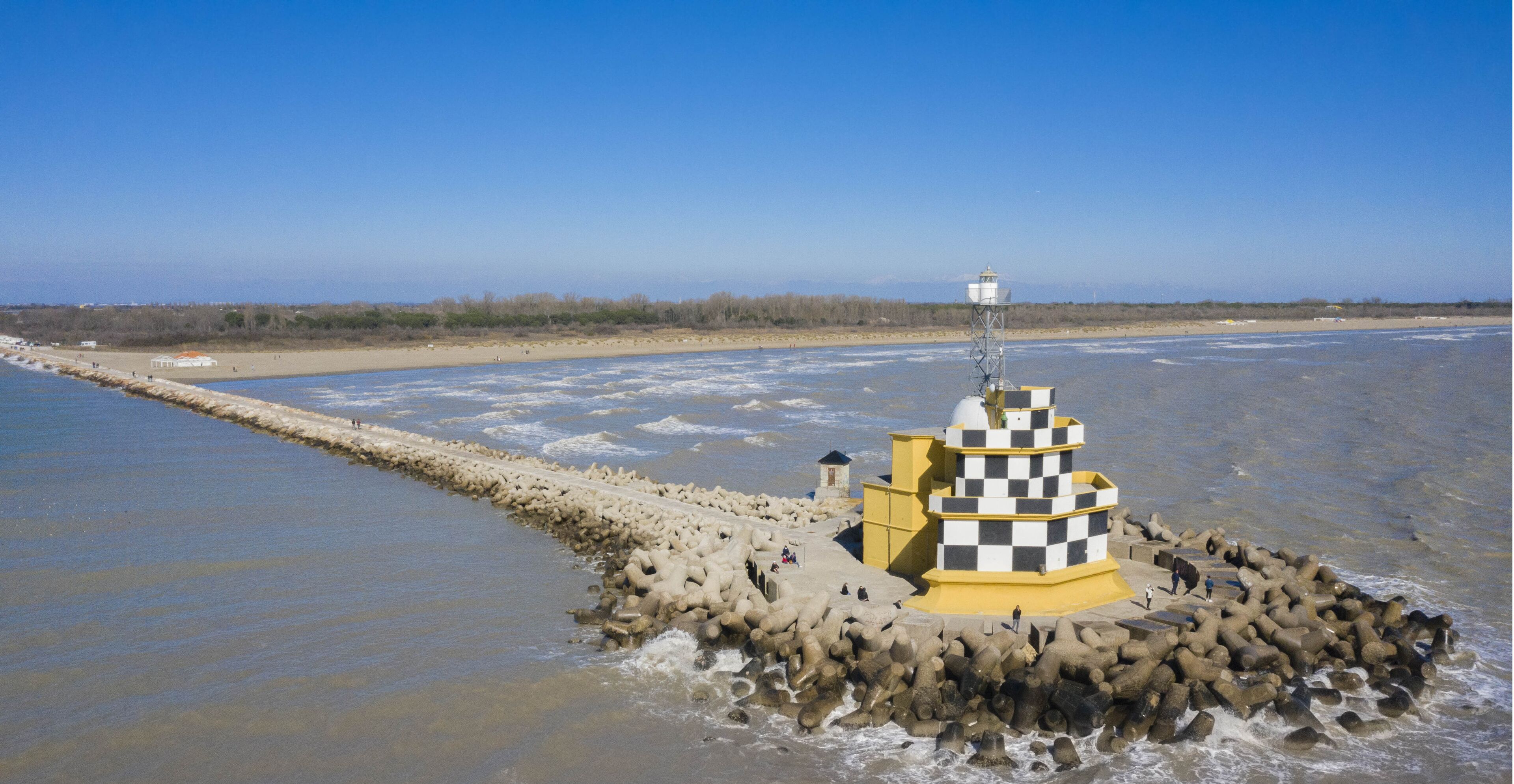 A lighthouse on a rocky outcrop in a coastal area.