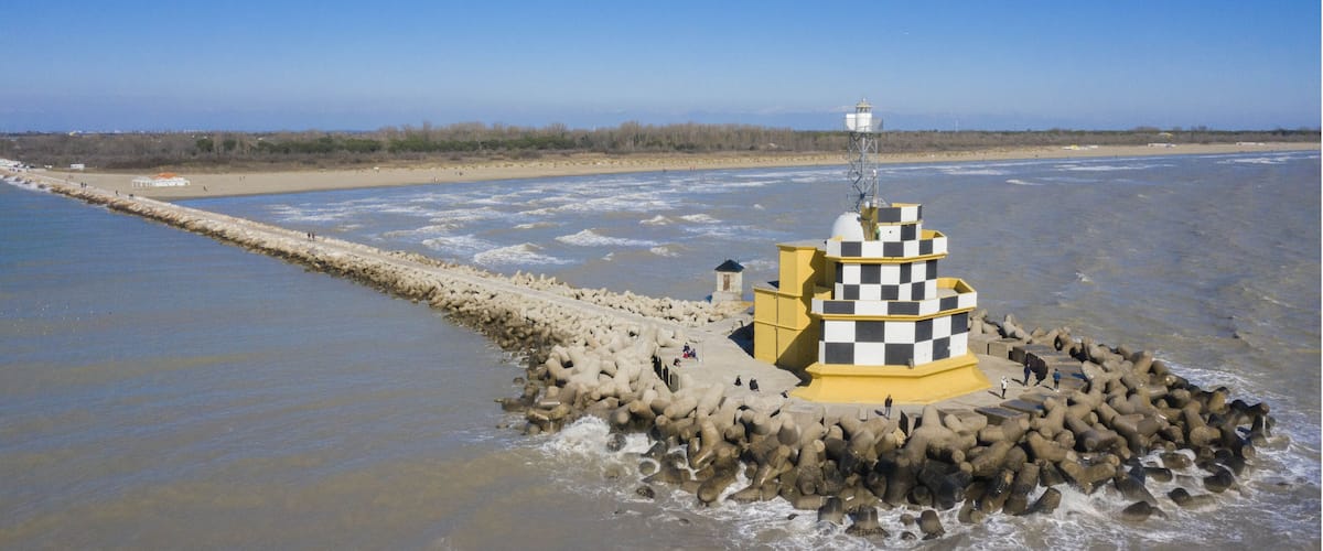 A lighthouse on a rocky outcrop in a coastal area.