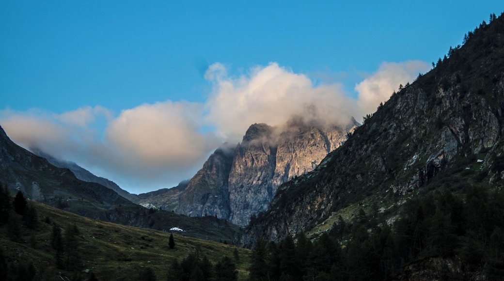 Ultimi raggi di sole di una giornata estiva si riflettono sulle pareti del monte Aga immerse in una coltre di nuvole.